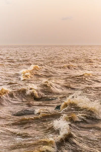 Ondas barrentas e agitadas tomam o Amazonas até o horizonte.